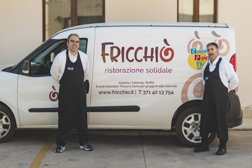 Due operatori del servizio Fricchiò Ristorazione Solidale davanti al veicolo utilizzato per le attività di catering e consegna