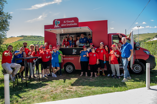 Partecipanti e operatori del progetto “Il Truck che Include” posano davanti al food truck durante un’attività di inclusione e partecipazione sociale.